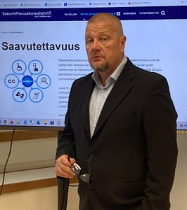 Saavutettavuusasiantuntija Jyri Hokkinen, IAAP CPACC. Jyri luennoi saavutettavuudesta seisoen suuren näytön edessä.